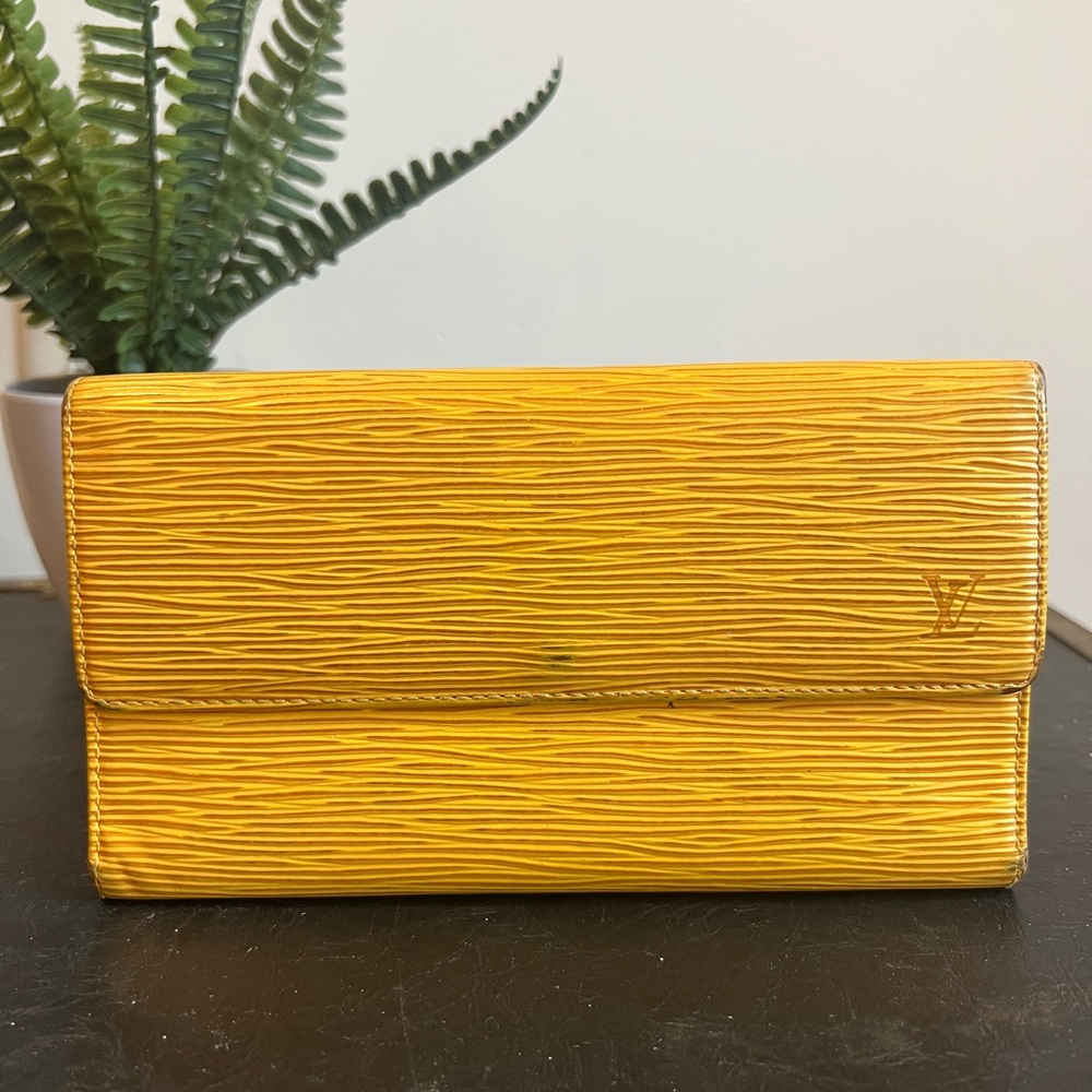 This is a yellow  (golden) Louis Vuitton Epi leather wallet.